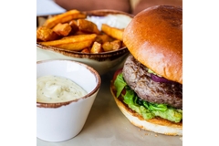 Junk food on a plate showing burger with fries and sauce